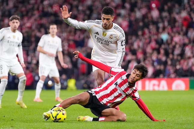 Pemain Real Madrid, Jude Bellingham, berebut bola dengan pemain Athletic Bilbao, Selton Sanchez, dalam laga La Liga di Bilbao, 3 Desember 2025 